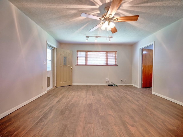 unfurnished room with ceiling fan, wood-type flooring, and a textured ceiling