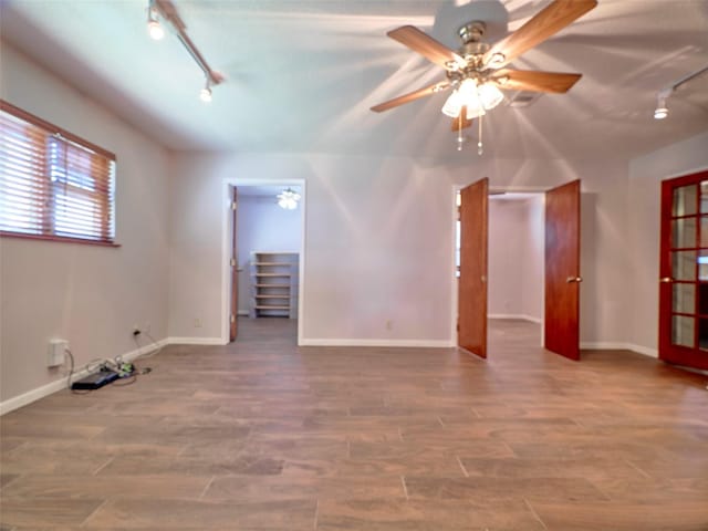 spare room featuring hardwood / wood-style flooring, rail lighting, and ceiling fan