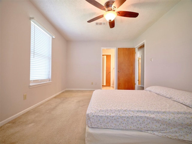 carpeted bedroom featuring ceiling fan and a textured ceiling