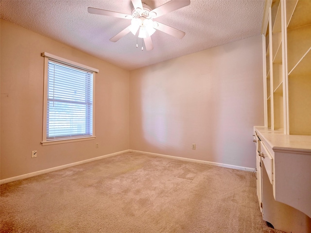 carpeted empty room featuring ceiling fan and a textured ceiling