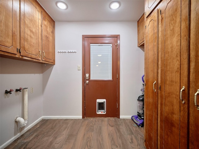 clothes washing area with cabinets and dark hardwood / wood-style flooring