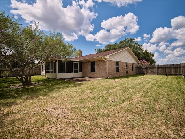 rear view of property featuring a sunroom and a lawn