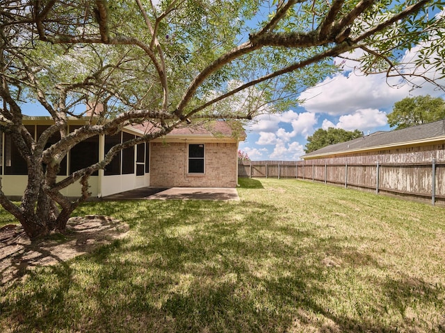 view of yard with a sunroom and a patio area