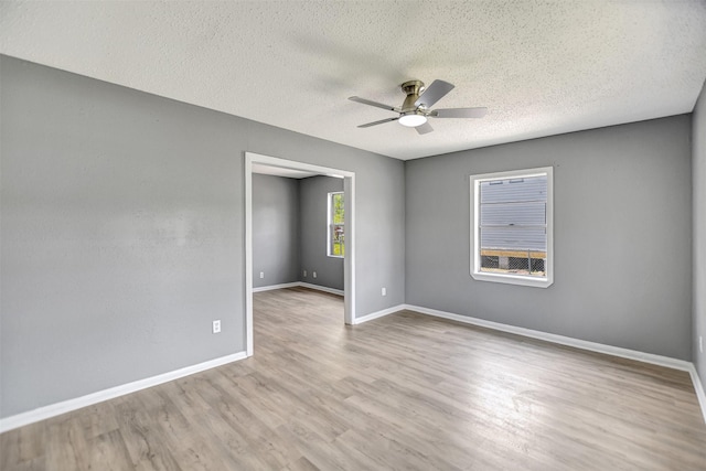 spare room featuring light hardwood / wood-style flooring, ceiling fan, and a textured ceiling