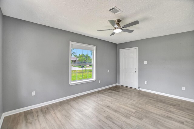 unfurnished room featuring a textured ceiling, hardwood / wood-style floors, and ceiling fan