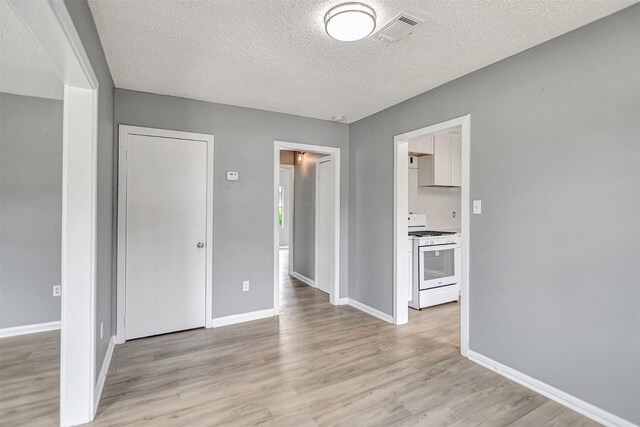 interior space with a textured ceiling and light wood-type flooring