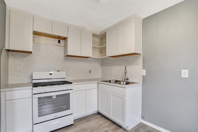 kitchen with light hardwood / wood-style floors, a textured ceiling, sink, and white gas range oven