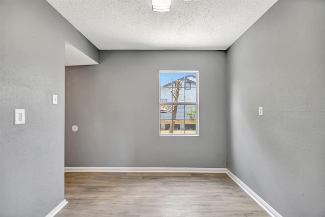 unfurnished room with a textured ceiling and hardwood / wood-style floors