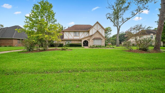 tudor home with a front lawn