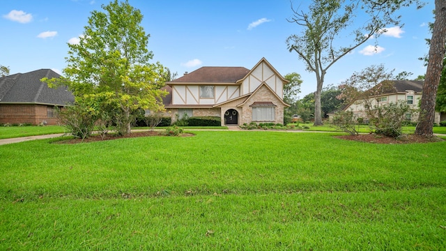 english style home featuring a front lawn