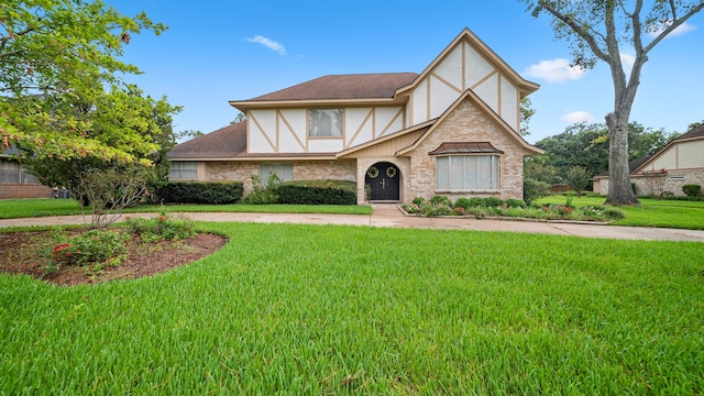 tudor-style house featuring a front yard