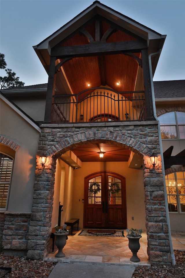 entrance to property featuring a balcony and french doors