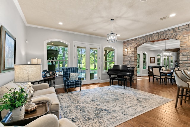 living room featuring a chandelier, hardwood / wood-style flooring, and crown molding