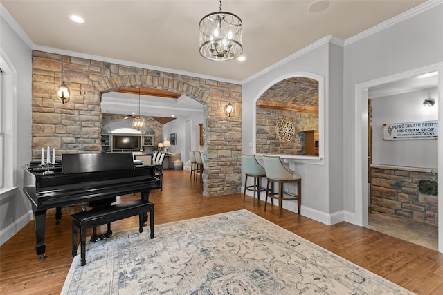 interior space with a notable chandelier, crown molding, and wood-type flooring