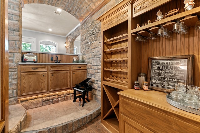 wine area featuring sink, hardwood / wood-style flooring, and crown molding