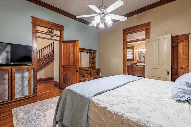 bedroom with dark hardwood / wood-style floors, crown molding, and ceiling fan