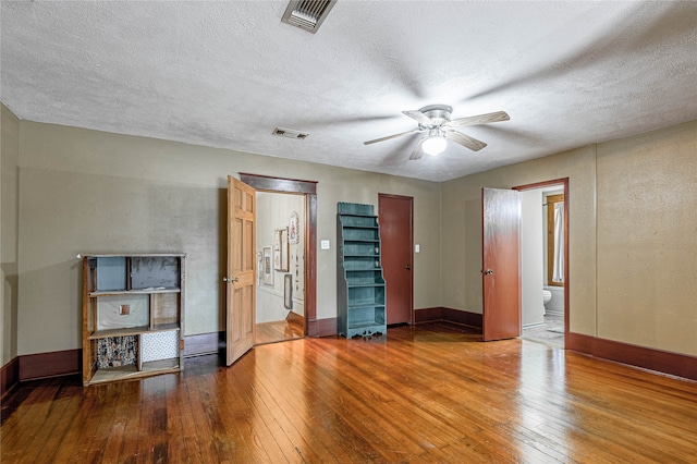 interior space with ceiling fan, a textured ceiling, and hardwood / wood-style flooring