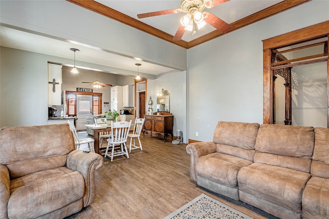 living room featuring ceiling fan, light wood-type flooring, and ornamental molding