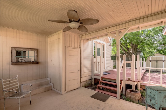 view of patio featuring a wooden deck, ceiling fan, and a storage unit