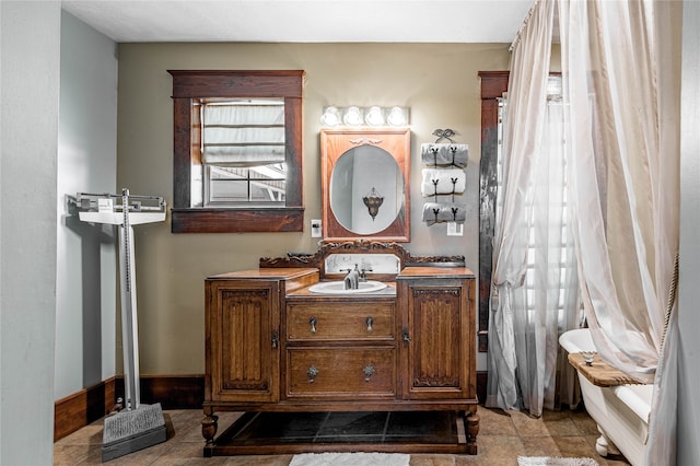 bathroom with tile patterned floors, vanity, and a healthy amount of sunlight