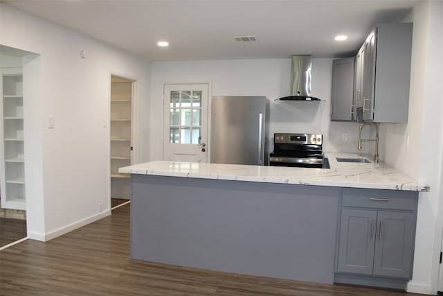 kitchen featuring stainless steel appliances, sink, kitchen peninsula, wall chimney exhaust hood, and gray cabinetry