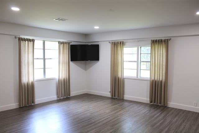 spare room featuring dark hardwood / wood-style flooring and a healthy amount of sunlight