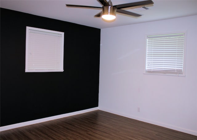 empty room featuring dark wood-type flooring and ceiling fan