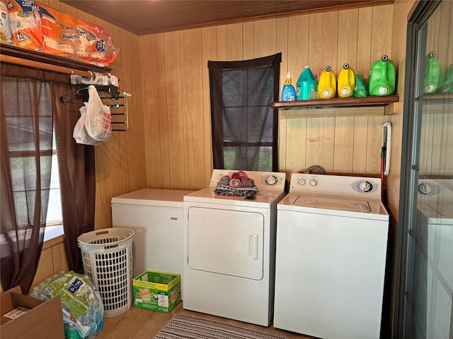 laundry room featuring hardwood / wood-style flooring, independent washer and dryer, and wooden walls