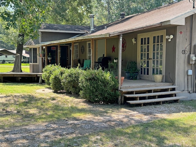 back of house with a yard, a wooden deck, and french doors