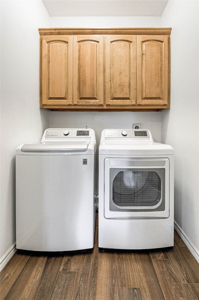 clothes washing area with cabinets, dark hardwood / wood-style flooring, and separate washer and dryer