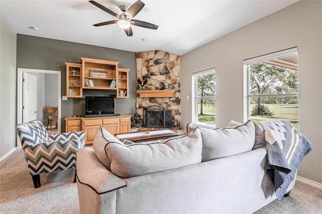 living room featuring a stone fireplace, carpet, and ceiling fan