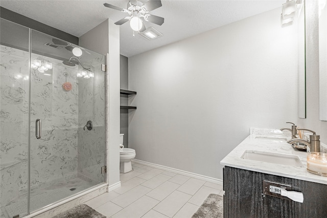 bathroom featuring ceiling fan, a shower with shower door, dual vanity, and toilet