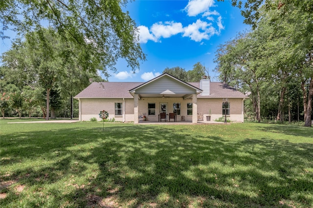 back of house featuring ceiling fan and a yard