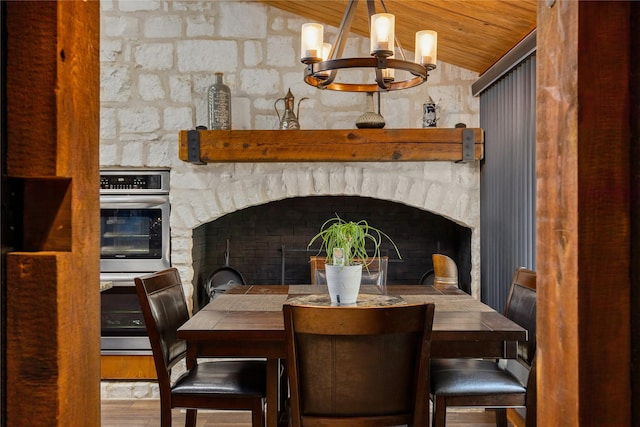 dining space featuring lofted ceiling, hardwood / wood-style floors, wood ceiling, and a chandelier