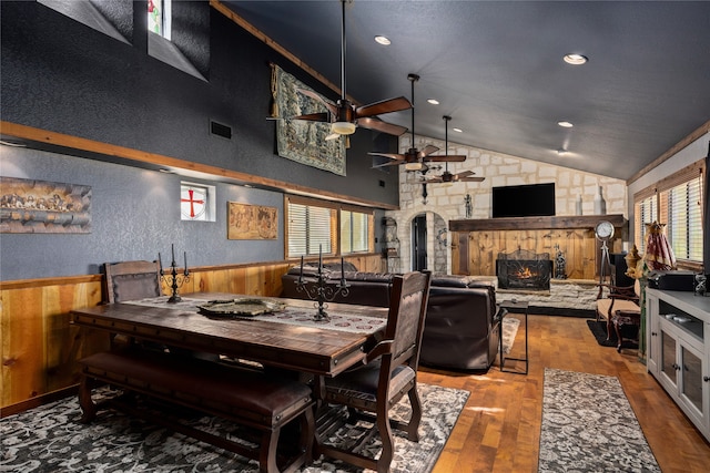 dining room with ceiling fan, high vaulted ceiling, plenty of natural light, and hardwood / wood-style floors