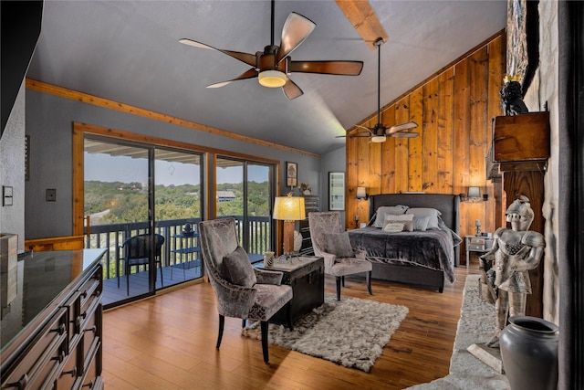 bedroom with wood walls, vaulted ceiling, access to exterior, and light hardwood / wood-style flooring