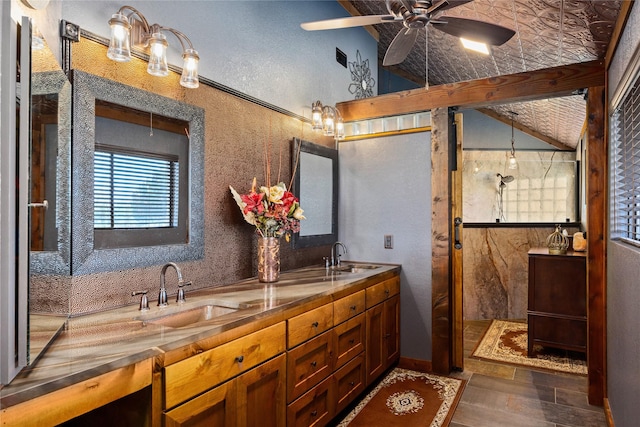 bathroom featuring a tile shower, vanity, vaulted ceiling, and ceiling fan