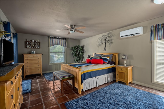 bedroom with ceiling fan, a wall mounted air conditioner, and a textured ceiling