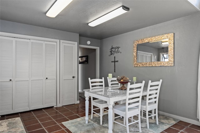 dining space with dark tile patterned flooring