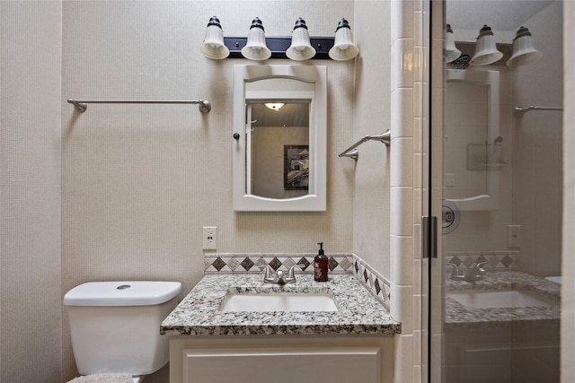 bathroom with an enclosed shower, vanity, and toilet