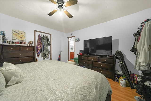 bedroom with ceiling fan, light hardwood / wood-style flooring, and ensuite bath