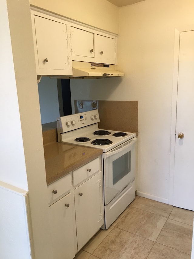 kitchen featuring white range with electric stovetop, light tile patterned floors, and white cabinets