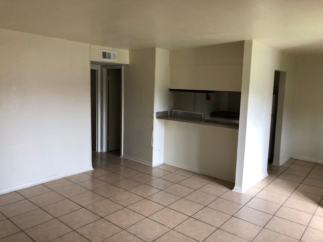 interior space with visible vents, baseboards, and light tile patterned floors