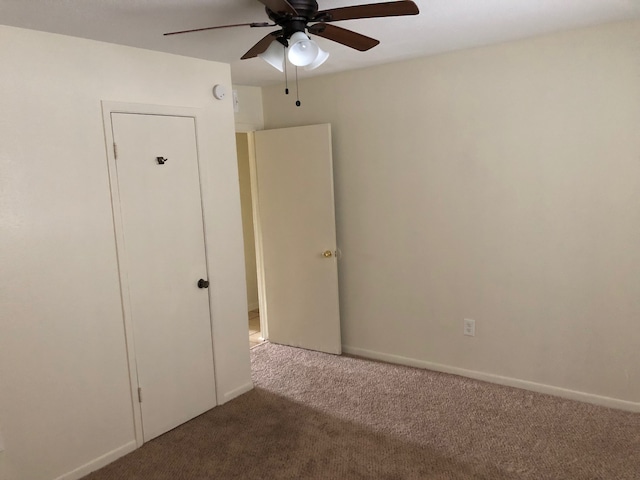 carpeted spare room with ceiling fan