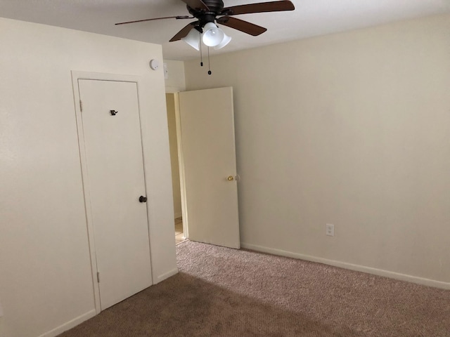 unfurnished bedroom featuring carpet floors, a ceiling fan, and baseboards