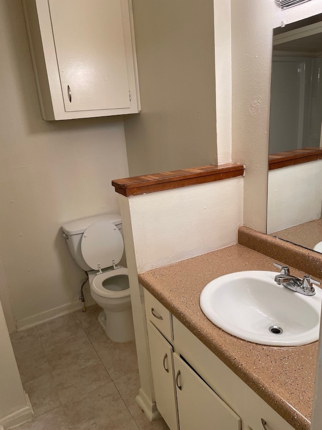 bathroom with tile patterned floors, vanity, and toilet