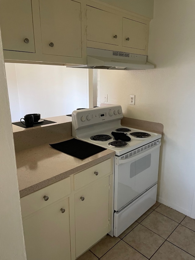 kitchen with light tile patterned flooring, electric stove, and premium range hood