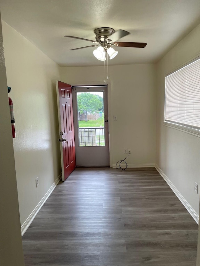 spare room featuring dark wood-style floors and baseboards