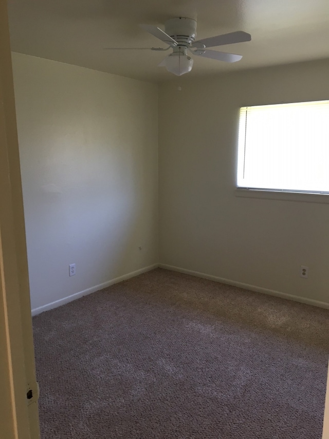 carpeted spare room with ceiling fan