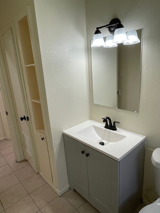 bathroom featuring vanity, tile patterned flooring, and toilet